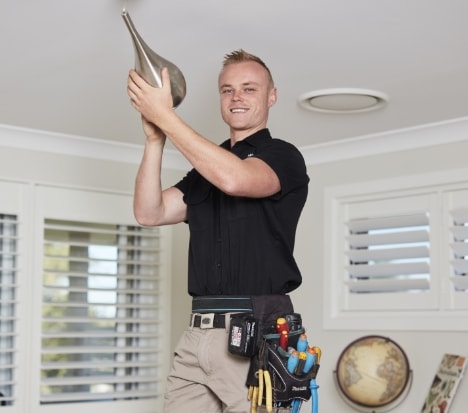 Sutherland electrician installing a pendant light
